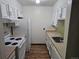 A kitchen with white cabinets, a white refrigerator, and a white stove/oven combo at 7665 E Eastman Ave # 104A, Denver, CO 80231