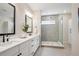 Modern bathroom with double vanity, quartz countertop, and a frameless glass shower at 14337 Shasta Daisy Pt, Parker, CO 80134