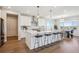 Bright kitchen with a large island, seating, and a dining area with scenic views at 14337 Shasta Daisy Pt, Parker, CO 80134