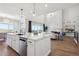 Bright kitchen with white cabinets, marble countertops, stainless steel appliances, and an open living space at 14337 Shasta Daisy Pt, Parker, CO 80134