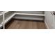 Walk-in pantry with white shelving and wood floor, maximizing storage in the home at 14337 Shasta Daisy Pt, Parker, CO 80134