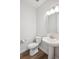 Clean powder room featuring a white pedestal sink, toilet, and a modern vanity mirror at 14337 Shasta Daisy Pt, Parker, CO 80134