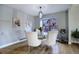 Elegant dining room featuring a glass table, white chairs, and hardwood floors at 3080 E Geddes Pl, Centennial, CO 80122