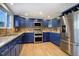 Modern kitchen featuring blue cabinets, granite countertops, and stainless steel appliances at 3080 E Geddes Pl, Centennial, CO 80122