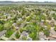 Aerial view features mountain backdrop with lush green neighborhood and well-manicured lawns and mature trees at 11305 W 78Th Dr, Arvada, CO 80005