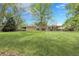 Expansive backyard with lush green lawn, mature trees, and a covered patio, ideal for outdoor living at 11305 W 78Th Dr, Arvada, CO 80005