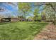 Expansive backyard featuring a lush lawn, a covered patio, mature trees, and a convenient carport at 11305 W 78Th Dr, Arvada, CO 80005