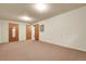Finished basement with carpet, multiple doors, and ample space for various activities and storage at 11305 W 78Th Dr, Arvada, CO 80005