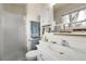 Bathroom featuring a single sink, vanity, shower with glass doors, and linen closet with a large window view at 11305 W 78Th Dr, Arvada, CO 80005