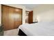Bedroom featuring a large closet with wood doors and wood trim to the connecting room at 11305 W 78Th Dr, Arvada, CO 80005