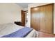 Bedroom featuring a large closet with wood doors and wood trim to the connecting room at 11305 W 78Th Dr, Arvada, CO 80005