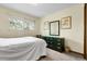 Bedroom with window view, a dark green dresser and matching mirror at 11305 W 78Th Dr, Arvada, CO 80005