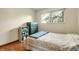 Bedroom with hardwood floors, window view, a green dresser and shelving unit at 11305 W 78Th Dr, Arvada, CO 80005