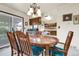 Dining room features a chandelier, wood table set with teal chairs and adjoins the kitchen at 11305 W 78Th Dr, Arvada, CO 80005