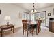 Cozy dining room with wood table set, chandelier, and sliding glass door to patio at 11305 W 78Th Dr, Arvada, CO 80005