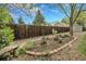 A charming garden bed with a wooden fence and a variety of plants and shrubs at 11305 W 78Th Dr, Arvada, CO 80005