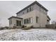 Exterior view of the back of a two story home with a patio, grill and snow-covered backyard at 17265 E 110Th Ct, Commerce City, CO 80022