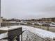 View of a backyard with a grill, snow-covered patio, and a neighborhood view at 17265 E 110Th Ct, Commerce City, CO 80022