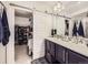 Bathroom with double vanity, sliding barn door to closet, and tiled flooring at 17265 E 110Th Ct, Commerce City, CO 80022