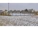 Gated community pool covered in snow, surrounded by modern homes at 17265 E 110Th Ct, Commerce City, CO 80022