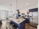 Open kitchen features an island with granite countertops, pendant lighting, and stainless steel appliances at 17265 E 110Th Ct, Commerce City, CO 80022