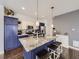 Spacious kitchen featuring an eat-in island with granite countertops and stylish navy blue cabinetry at 17265 E 110Th Ct, Commerce City, CO 80022