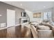 Cozy living room featuring hardwood floors, modern decor, fireplace, and a comfortable sectional sofa at 17265 E 110Th Ct, Commerce City, CO 80022
