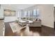 Bright living room featuring a large sectional sofa, modern finishes, hardwood floors, and natural light at 17265 E 110Th Ct, Commerce City, CO 80022