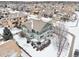 Two-story house with deck, in a snow-covered neighborhood, aerial view at 5008 S Nepal St, Centennial, CO 80015