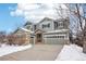 Two-story house with gray siding, stone accents, and a three-car garage at 5008 S Nepal St, Centennial, CO 80015