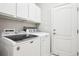 Bright laundry room with washer, dryer, and cabinets at 5008 S Nepal St, Centennial, CO 80015