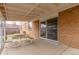 Covered patio area with a picnic table is attached to the brick home and provides an entertaining space at 1410 S Grant St, Longmont, CO 80501