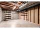 Unfinished basement featuring concrete floor, exposed ceiling, and wooden shelving for storage at 1410 S Grant St, Longmont, CO 80501