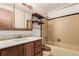 Well-lit bathroom with a single sink vanity and a tiled shower-tub with shelving at 1410 S Grant St, Longmont, CO 80501