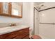 Well-lit bathroom featuring a single sink vanity and a tiled walk-in shower with black accent tile at 1410 S Grant St, Longmont, CO 80501