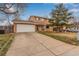 Two-story home featuring a two car garage, driveway and mature tree in front yard at 1410 S Grant St, Longmont, CO 80501