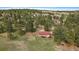 Aerial view of a charming red roofed home nestled among trees in a serene, rural setting at 3337 Ponderosa Rd, Franktown, CO 80116