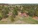 A charming home with a red roof nestled in a green lot is surrounded by mature trees at 3337 Ponderosa Rd, Franktown, CO 80116