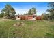 Back exterior featuring a wooden fence, wood siding, and mature trees surrounding the home at 3337 Ponderosa Rd, Franktown, CO 80116
