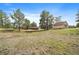 A home and outbuilding stand near each other on a large lot with mature trees in a private setting at 3337 Ponderosa Rd, Franktown, CO 80116