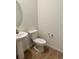 Half bathroom with a pedestal sink, modern faucet, and a decorative mirror and wood-look floors at 9041 Redfield Ln, Parker, CO 80134