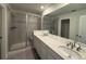 En-suite bathroom featuring dual sinks, a glass enclosed shower, and tile flooring at 9041 Redfield Ln, Parker, CO 80134