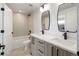 Modern bathroom with double vanity, quartz countertop, bathtub and black fixtures at 1953 W 47Th Ave, Denver, CO 80211