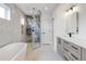 Bright bathroom featuring marble tiling, walk-in shower, and modern vanity at 1953 W 47Th Ave, Denver, CO 80211