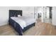 Bright bedroom featuring hardwood floors, a stylish bed, and access to a modern bathroom at 1953 W 47Th Ave, Denver, CO 80211