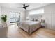 Bright bedroom features a ceiling fan, hardwood floors, sliding glass door, and neutral decor at 1953 W 47Th Ave, Denver, CO 80211