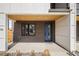 Inviting front entrance with a modern blue door, brick facade, and covered porch with wood ceiling at 1953 W 47Th Ave, Denver, CO 80211