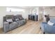 Modern living room featuring a gray reclining sofa, stylish bar area, and light hardwood floors at 1953 W 47Th Ave, Denver, CO 80211