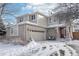 Two-story house with attached garage, snowy landscape, and a red front door at 20242 E Lasalle Pl, Aurora, CO 80013