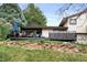 Spacious backyard featuring a large deck, stone landscaping, and lush greenery at 6389 S Monaco Ct, Centennial, CO 80111